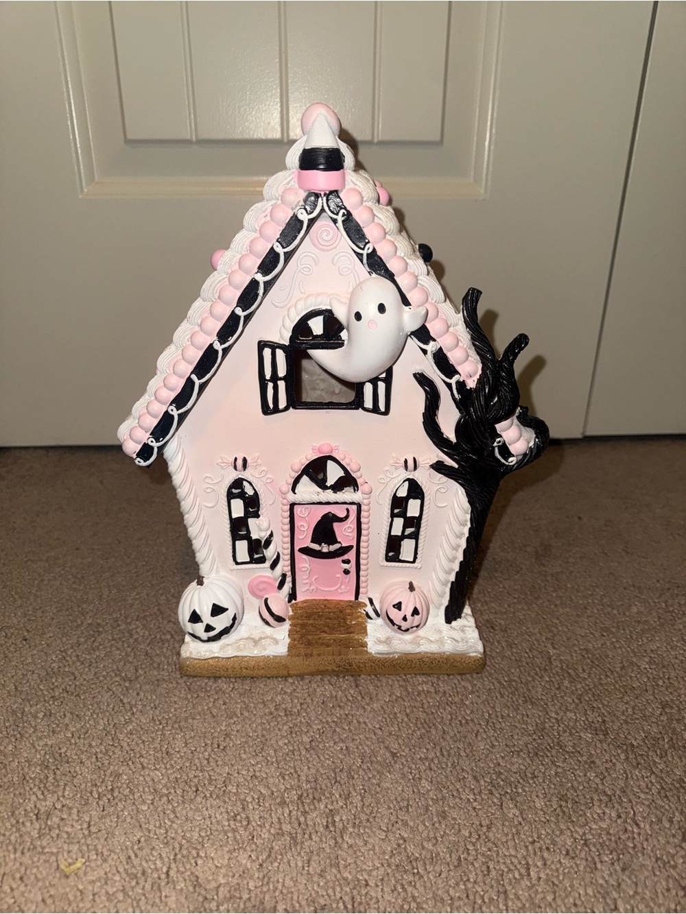 pink and black Halloween gingerbread house is a ceramic light-up figurine